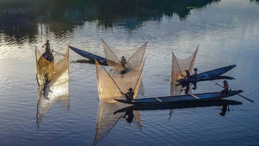 Fishermen raise their nets on the Perfume River in Hue, Vietnam. (Photo by Teberik kölgeli )